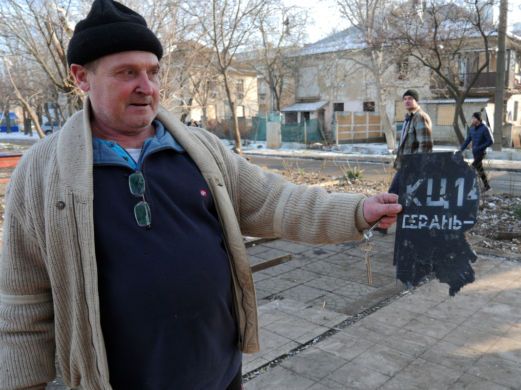 Потерпілий від російської атаки показує уламок російського дрона у своєму дворі 