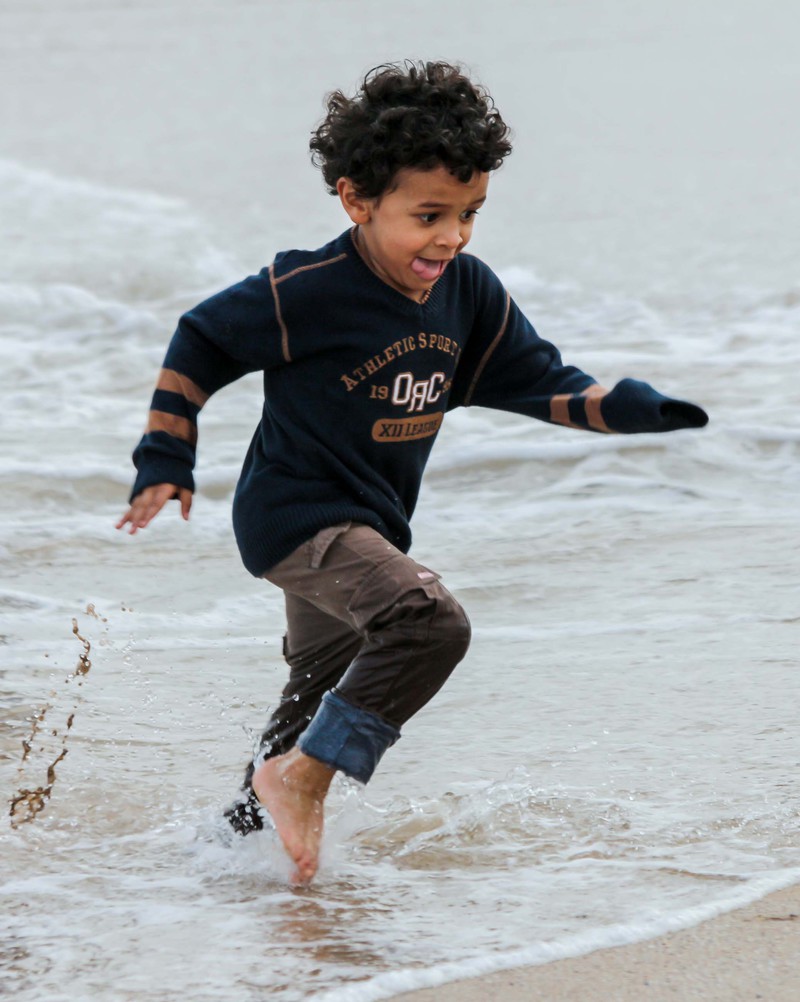 Children playing in the waves in the sea waves