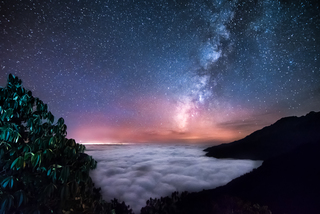 Milky way above the clouds ocean