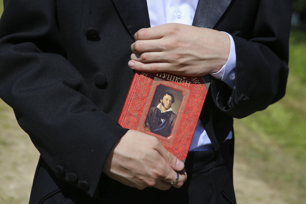 Молодой человек в костюме XIX века с томиком Пушкина