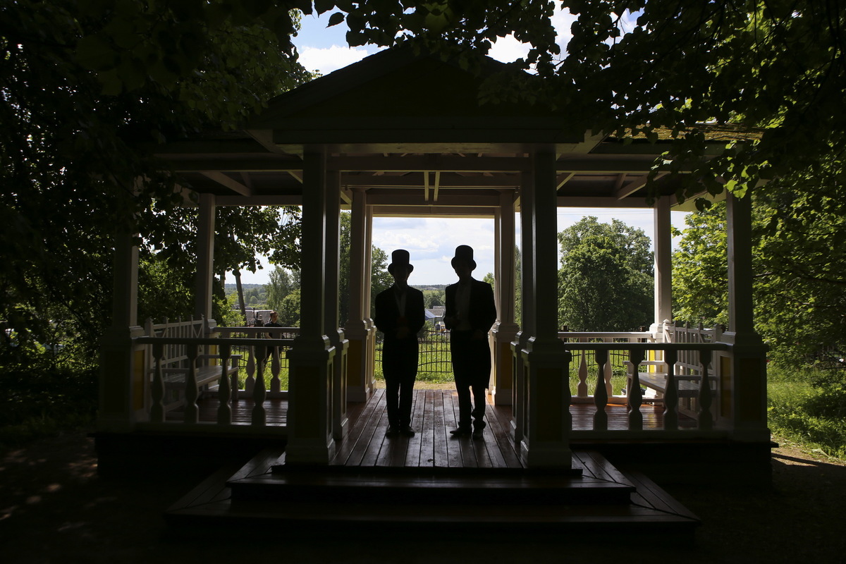 Молодые люди, одетые в костюмы XIX века, в бесседке