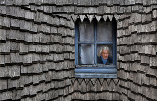 Vrouwtje achter raam persp