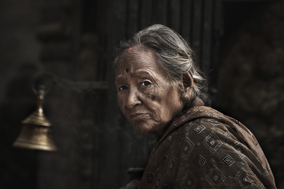 old woman with praying bell