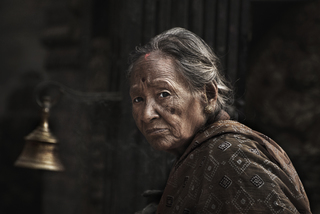 old woman with praying bell