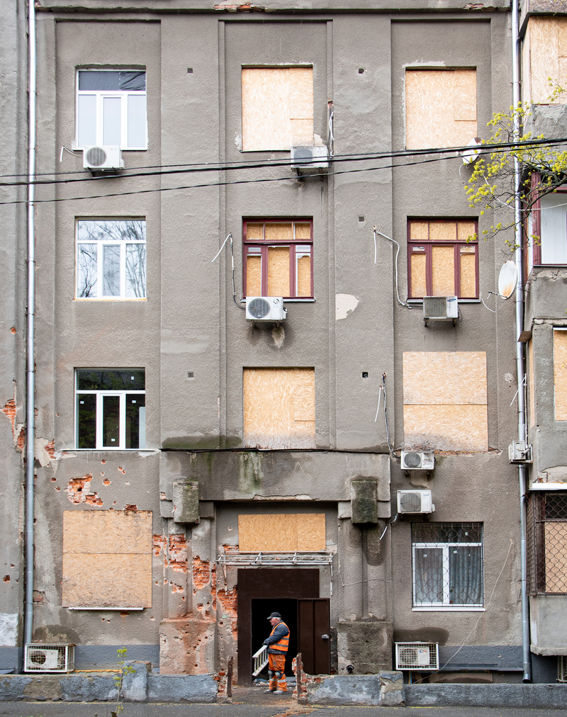 Працівник ремонтної бригади біля будинку 